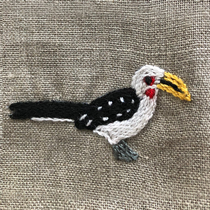 Embroidered hornbill on linen serviette